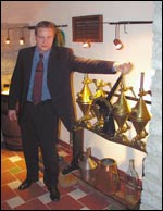 Livikon markkinointijohtaja Janek Kalvi näyttää millaisella laitteella viinaa pumpattiin pulloon vuonna 1898, kun Liviko aloitti toimintansa.